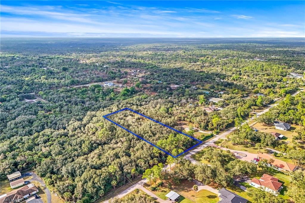 Aerial view of a vacant wooded lot among homes in Golden Gate Estates, Naples, Florida